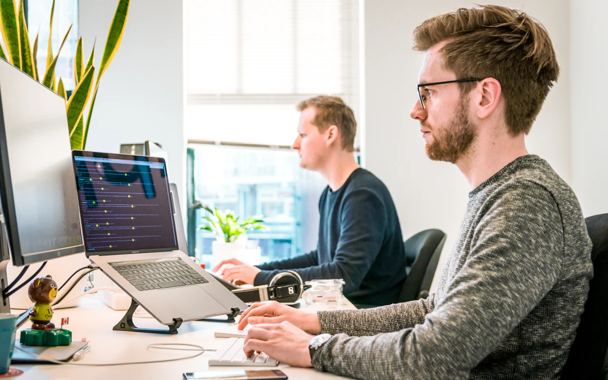 Two colleagues working at computers in a bright office