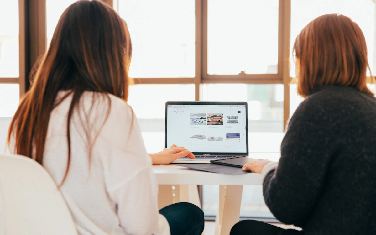 Two colleagues discussing work on a laptop